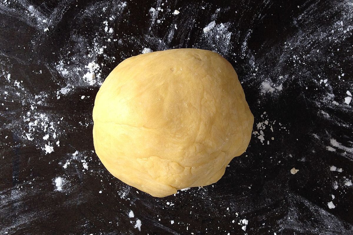 Bola de massa fresca de ovos sobre bancada enfarinhada