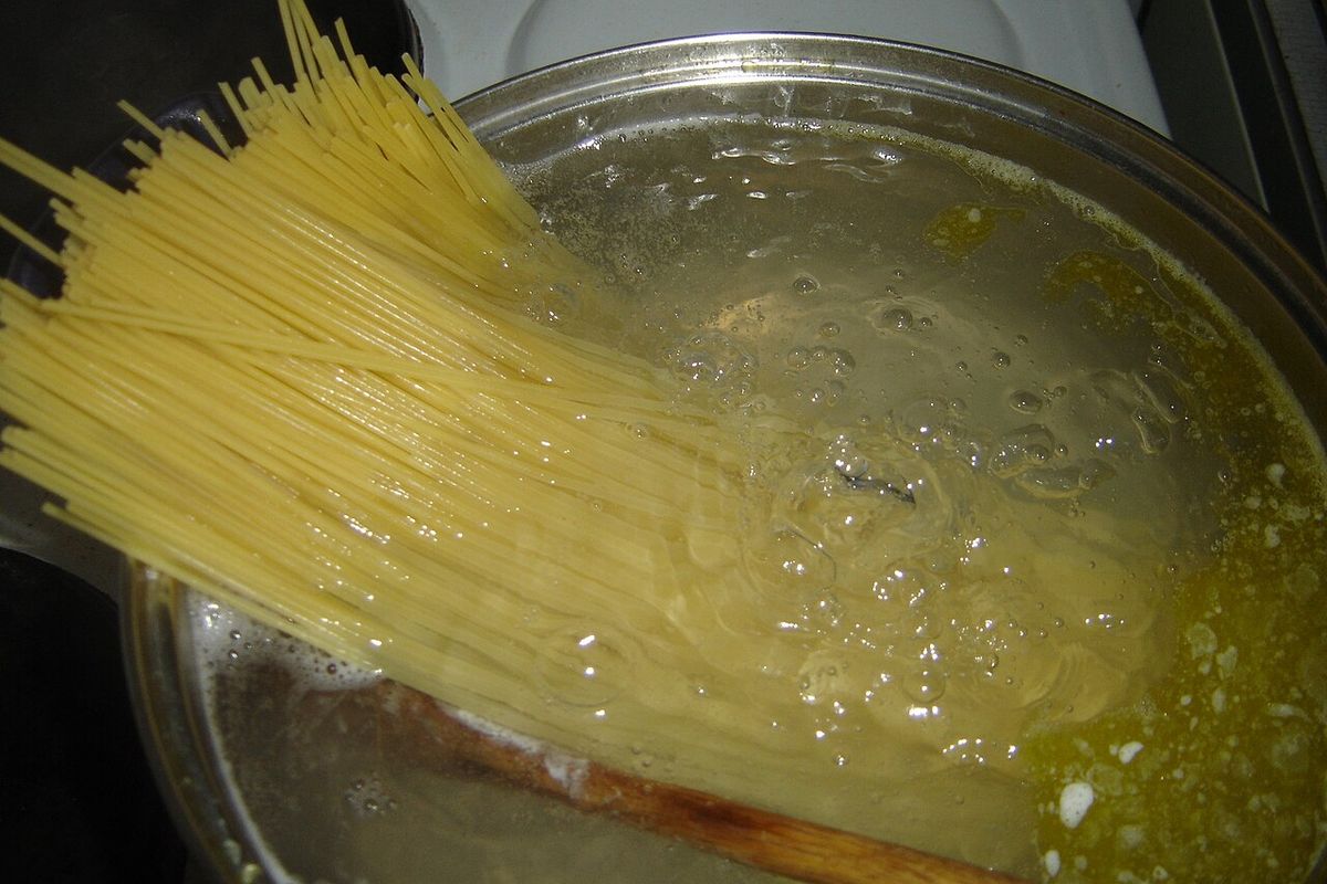 Espaguete sendo cozido em panela com água fervente