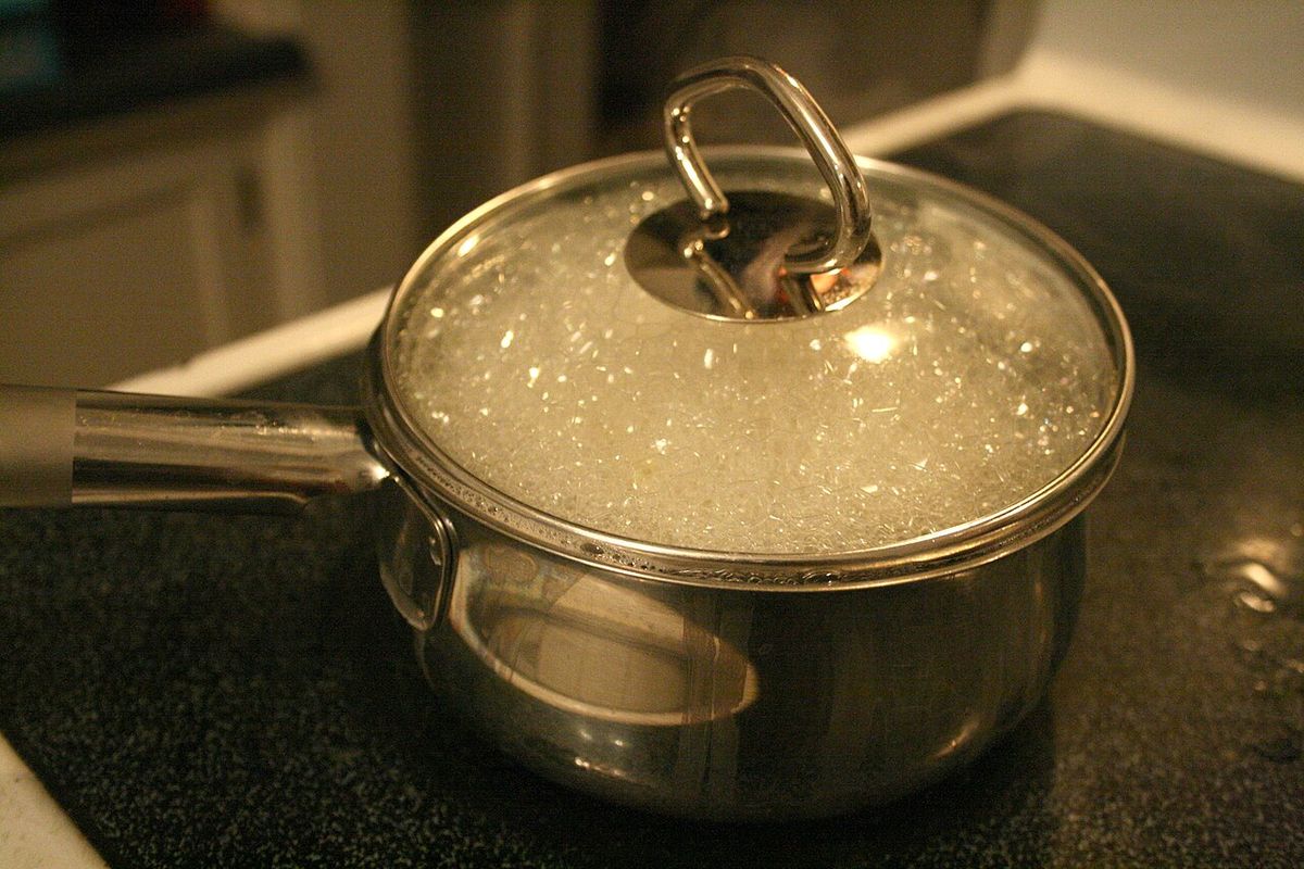 Panela com água fervendo e massa cozinhando no fogão