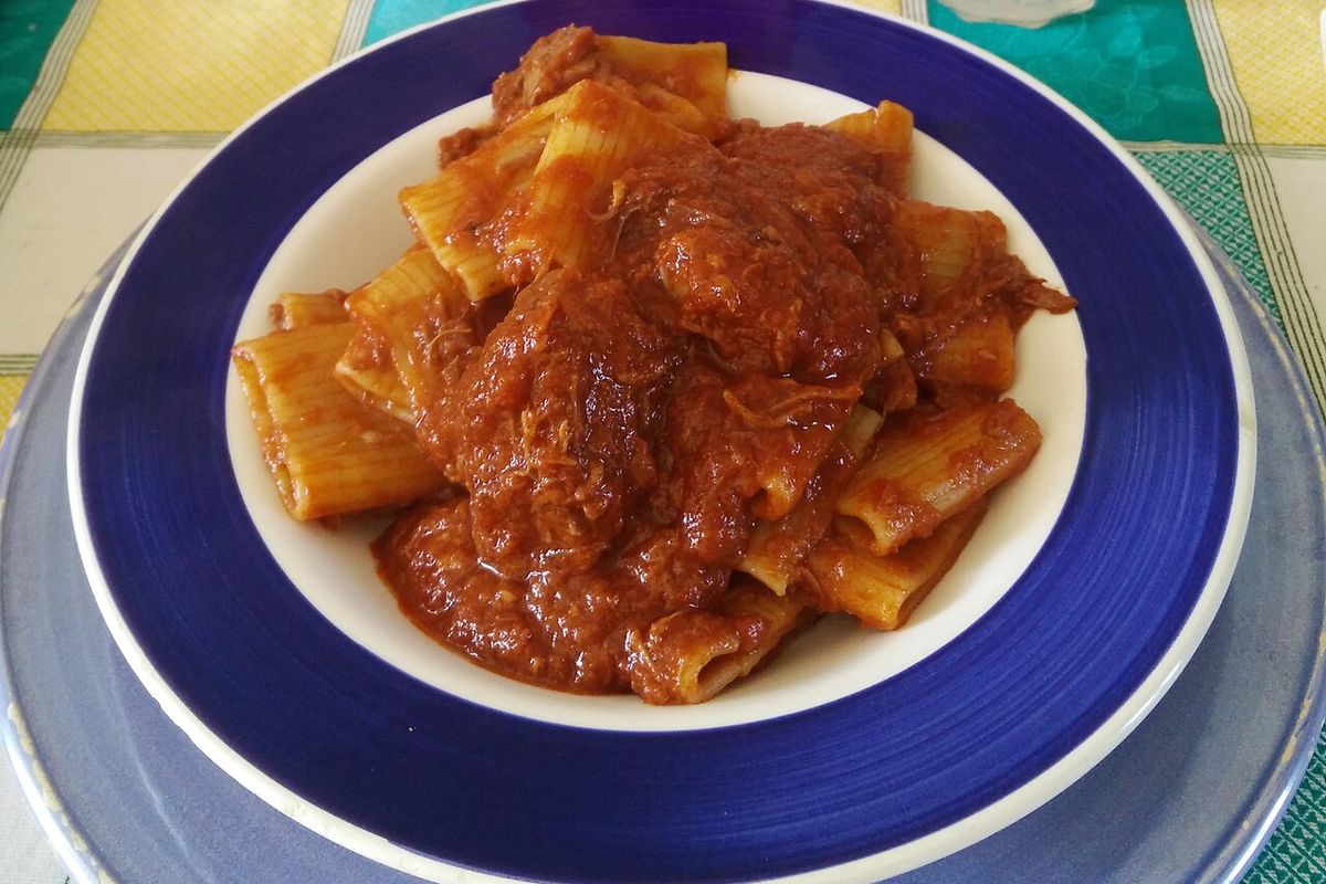 Paccheri ao ragù napolitano em prato azul e branco