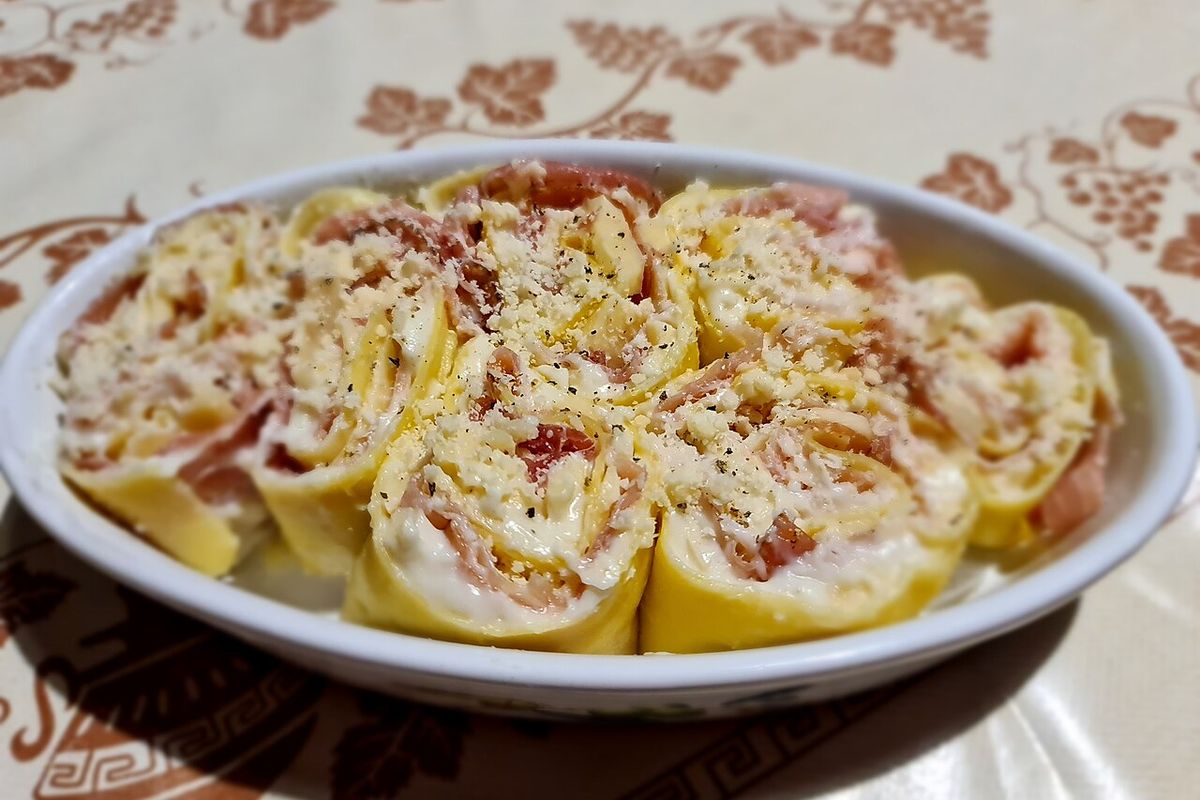 Rolinhos de massa recheados com presunto e queijo, prontos para o forno